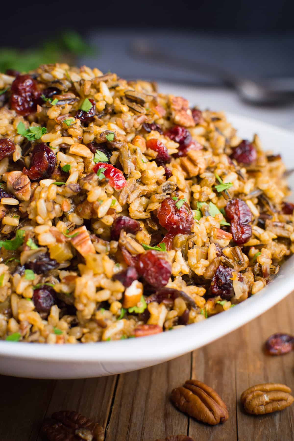 Wild rice stuffing with cranberries and pecans in a white serving bowl.