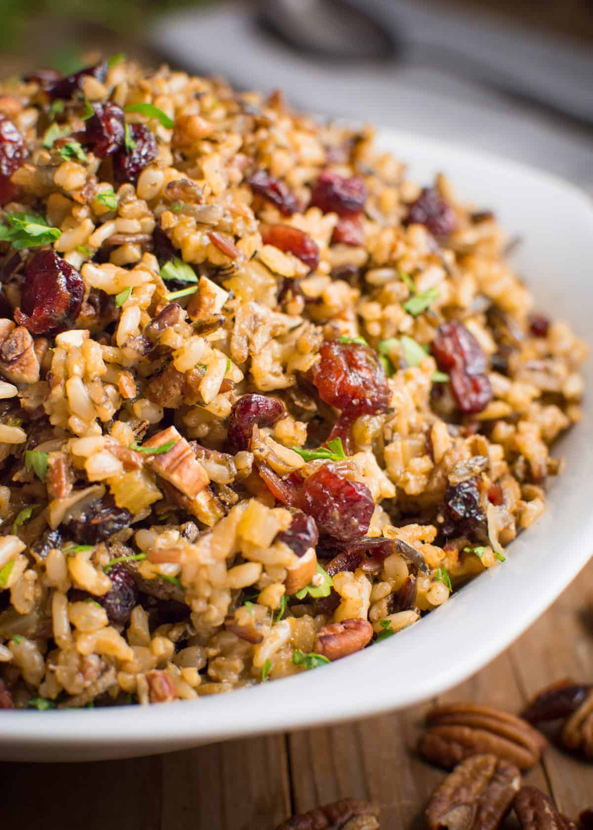 Wild rice stuffing with dried cranberries and toasted pecans in a white bowl.