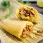 A vegan tamale with a jackfruit filling on a corn husk.