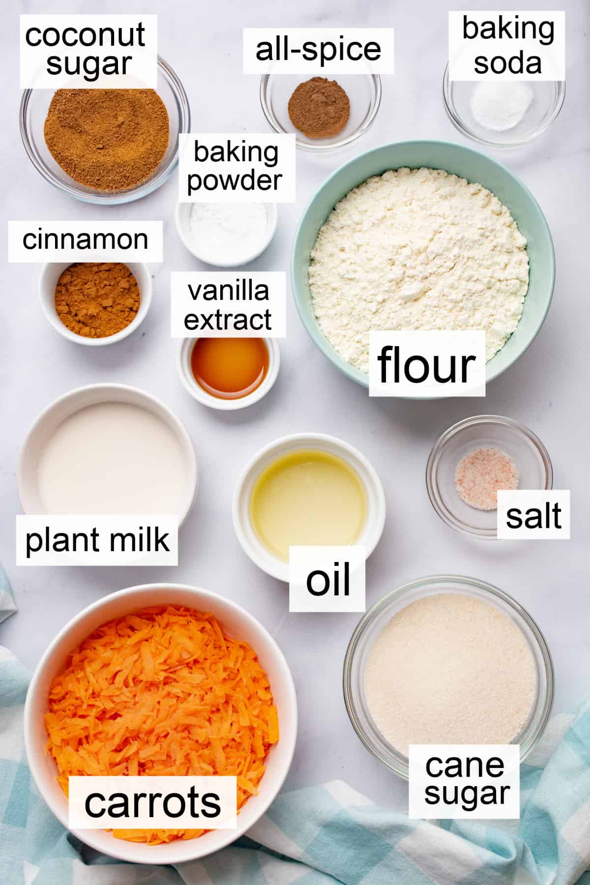 Vegan carrot cake ingredients in separate bowls and labeled.