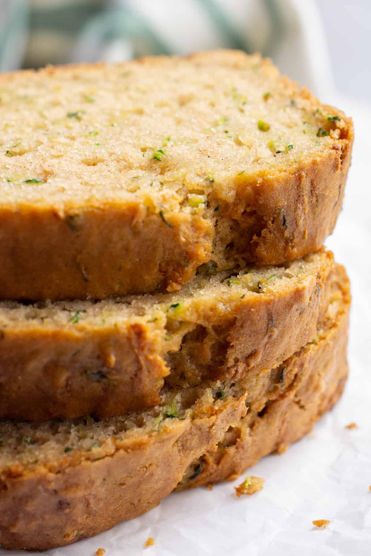 Three stacked slices of zucchini bread.