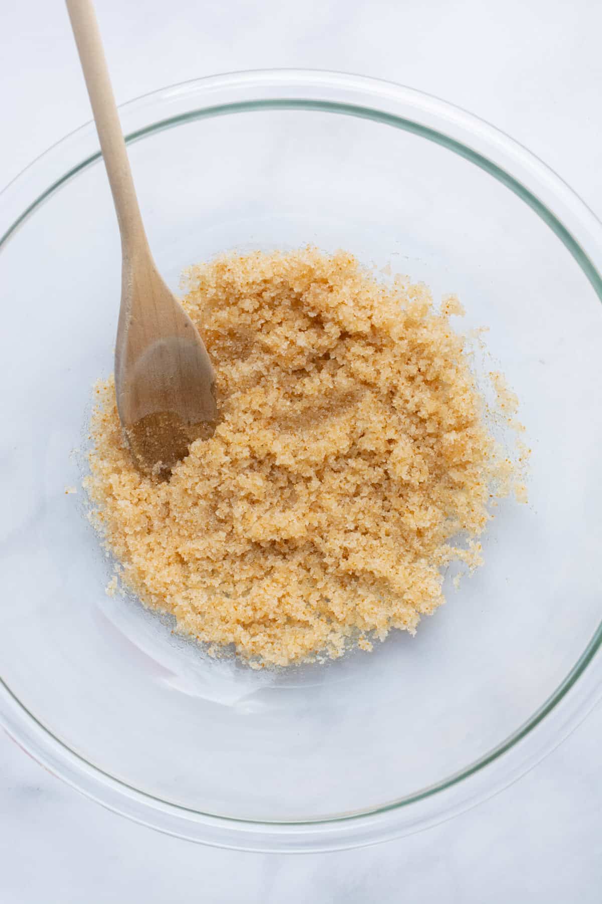 Oil and sugar mixed in a glass bowl.