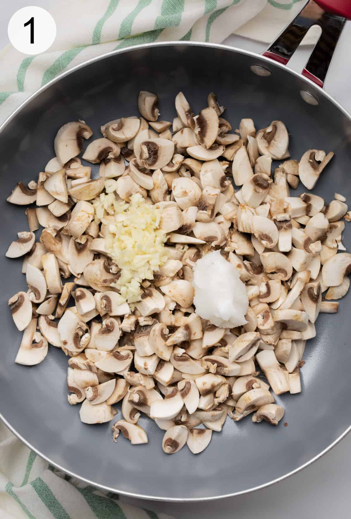 Diced mushrooms, minced garlic, and coconut oil in a large non-stick ceramic frying pan.