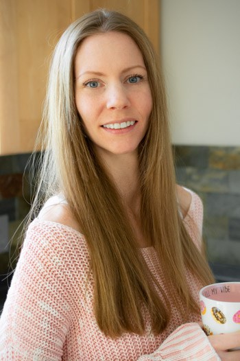 Marlena Luna in a pink sweater holding a coffee mug.