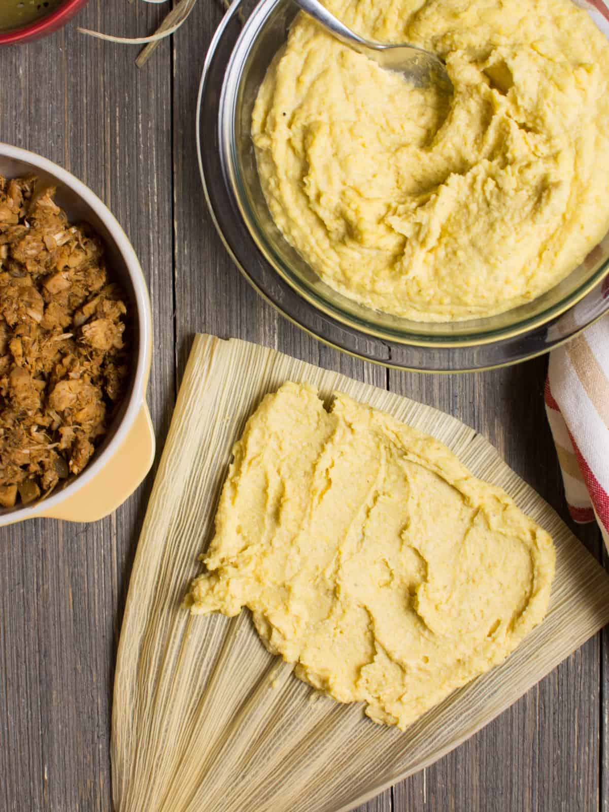 A corn husk with corn masa spread across.