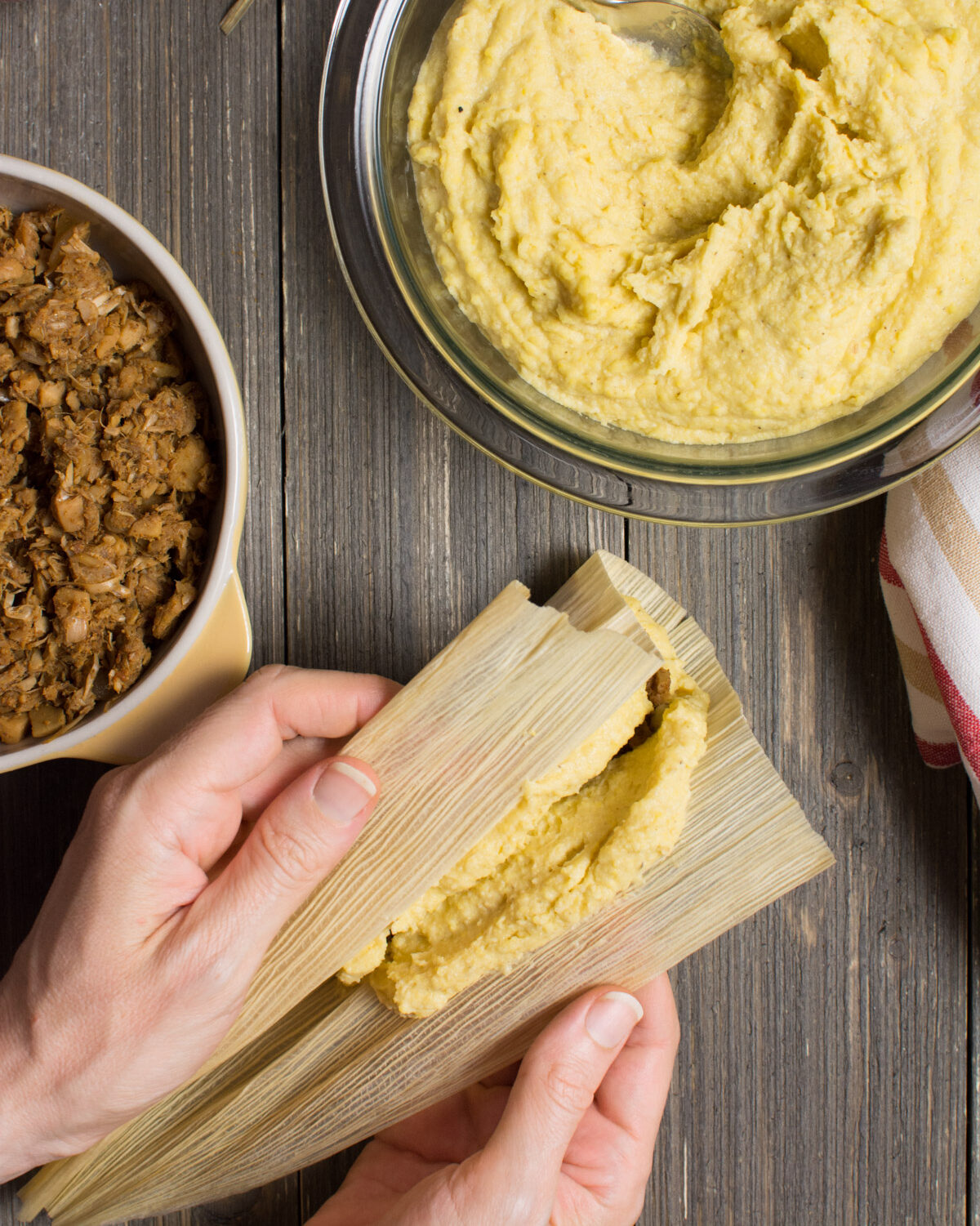 hands closing up a tamale.