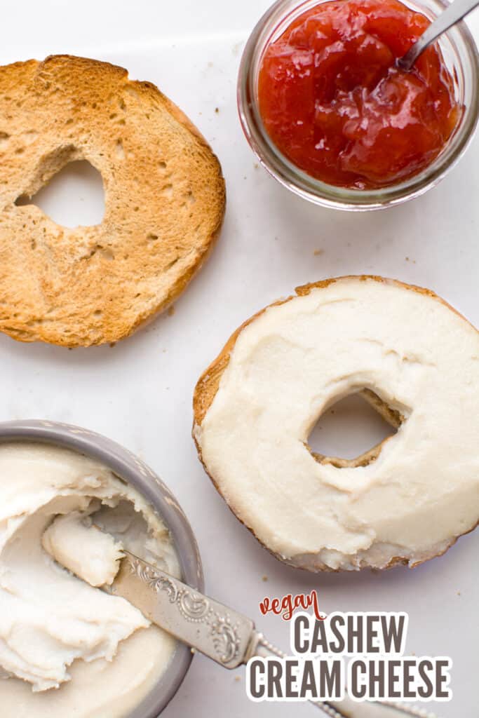 Cashew cream cheese spread on a toasted bagel with writing for Pinterest.