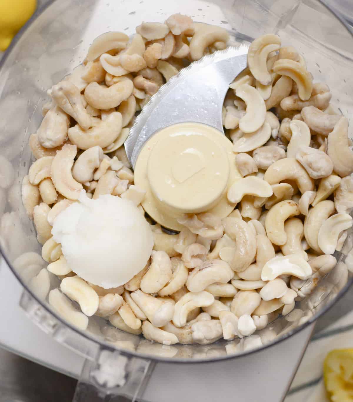 Soaked cashews, lemon juice, and coconut oil in a food processor.