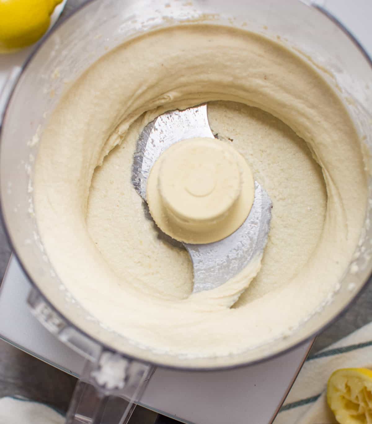 A food processor with blended cashews.