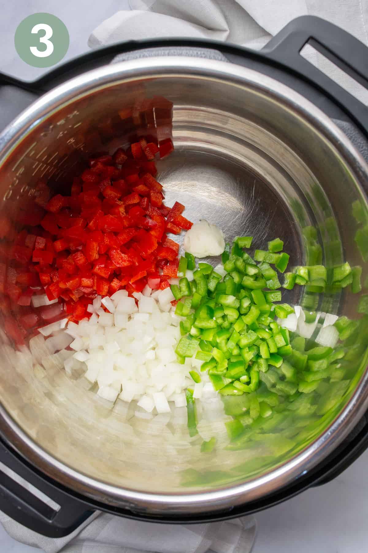 Chopped bell peppers, onion, jalapeño peppers, and a bit of oil in the Instant Pot.