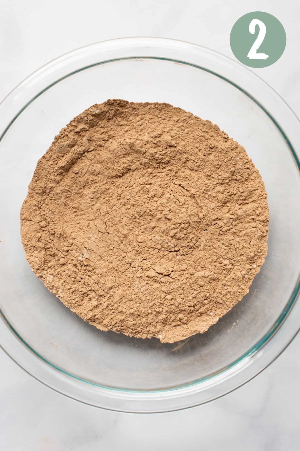 Flour, cocoa powder, salt, and baking powder mixed in a glass bowl.