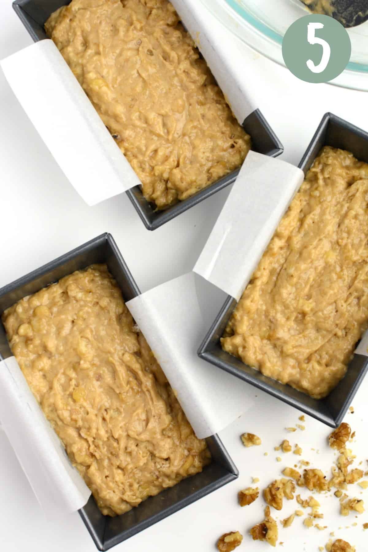 Vegan banana bread batter in 3 mini loaf pans.