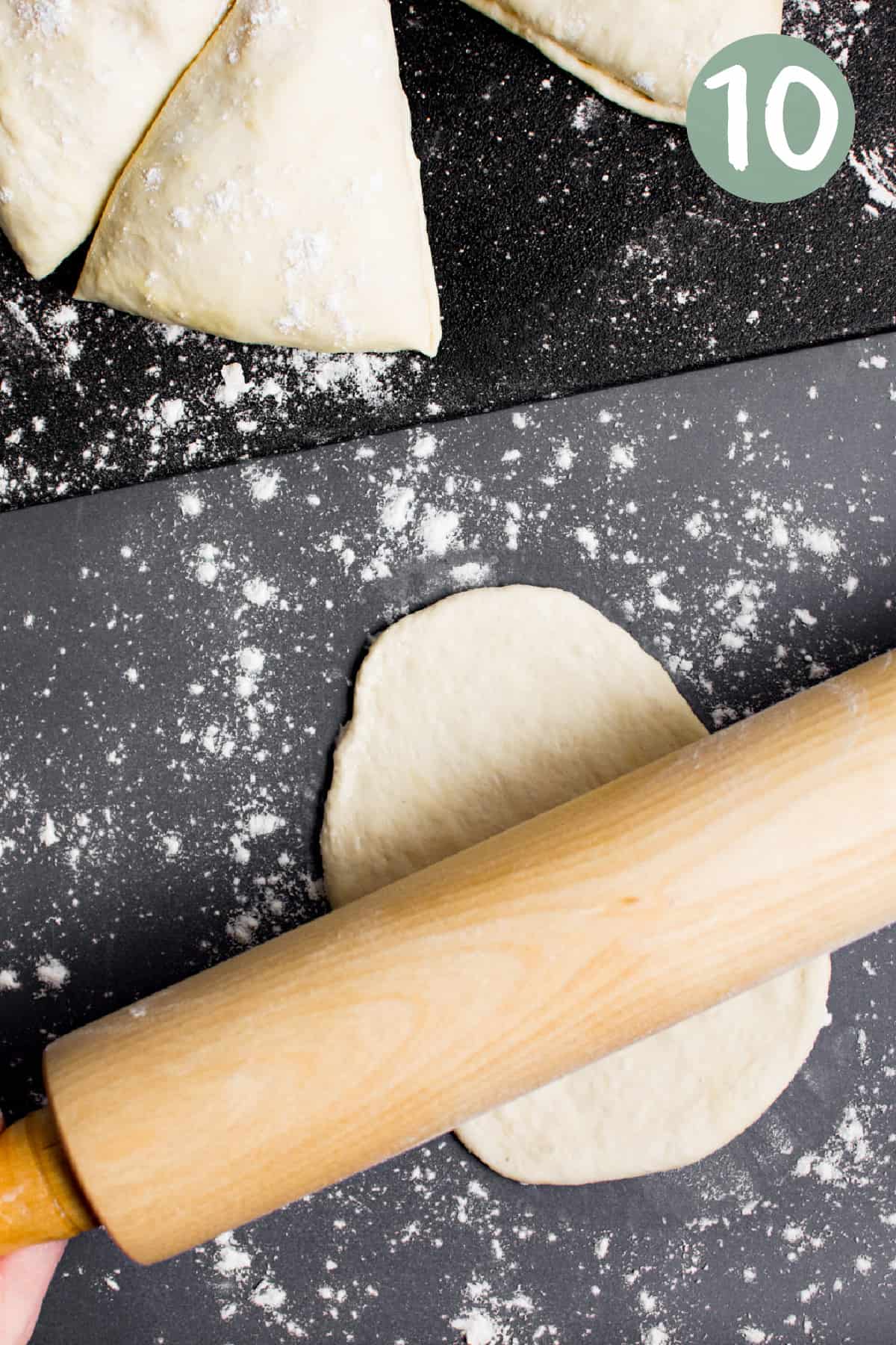 A rolling pin rolling dough out into an oval naan.