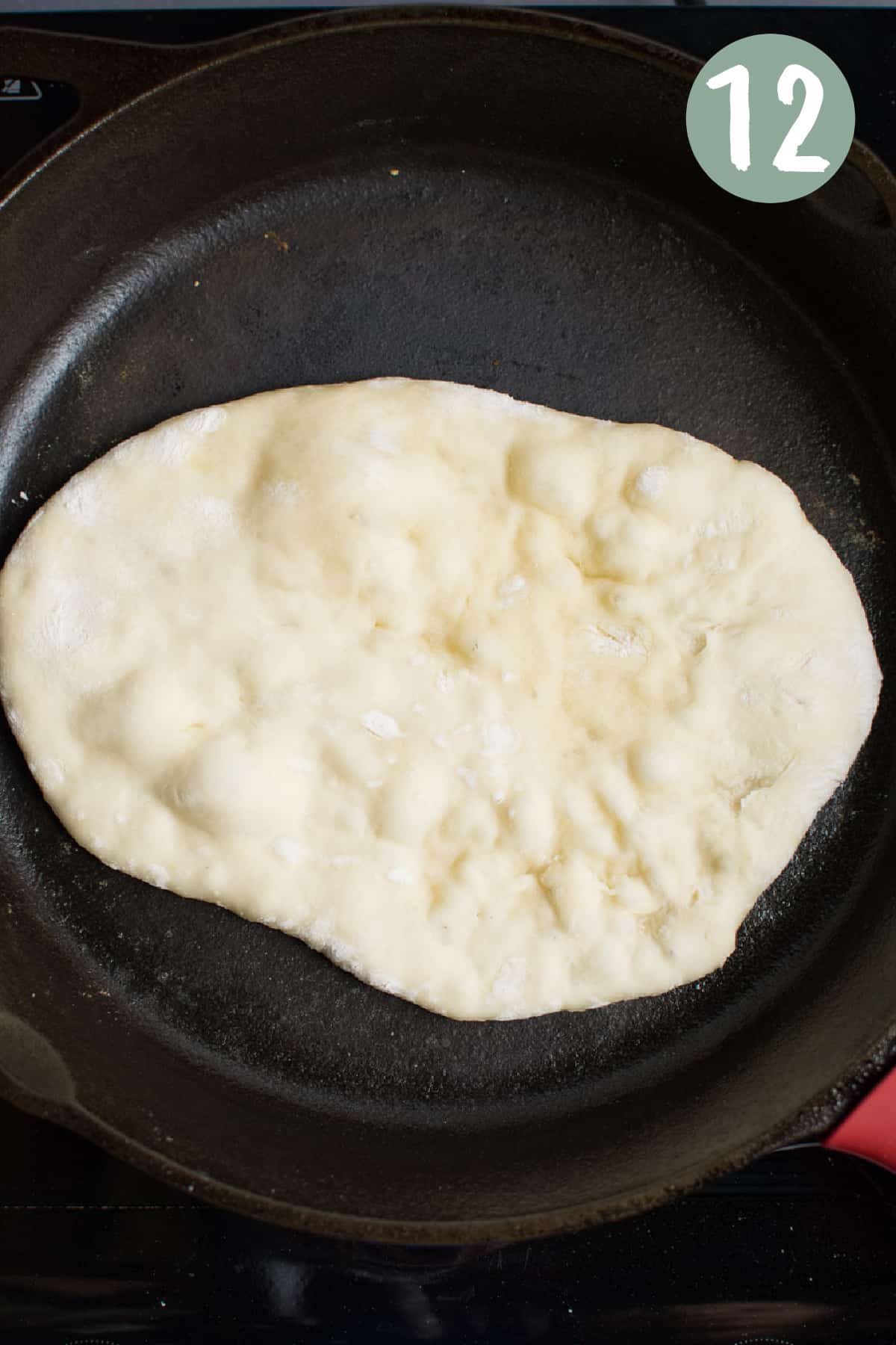 Naan dough cooking on a skillet. 