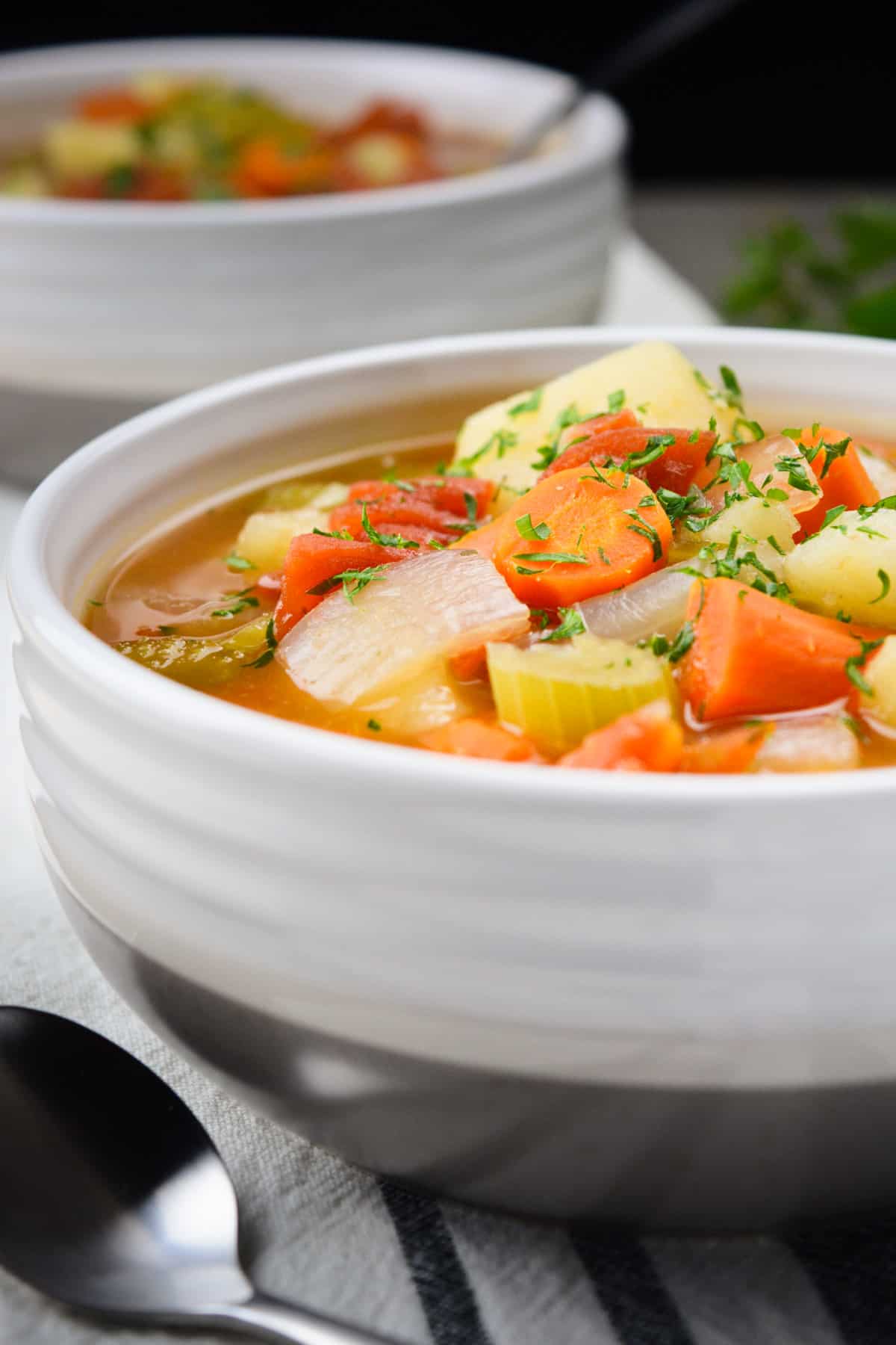 Vegetable Soup in a white bowl with a spoon.