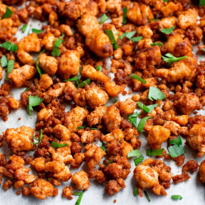 tofu ground beed on parchment paper topped with fresh chopped parsley.