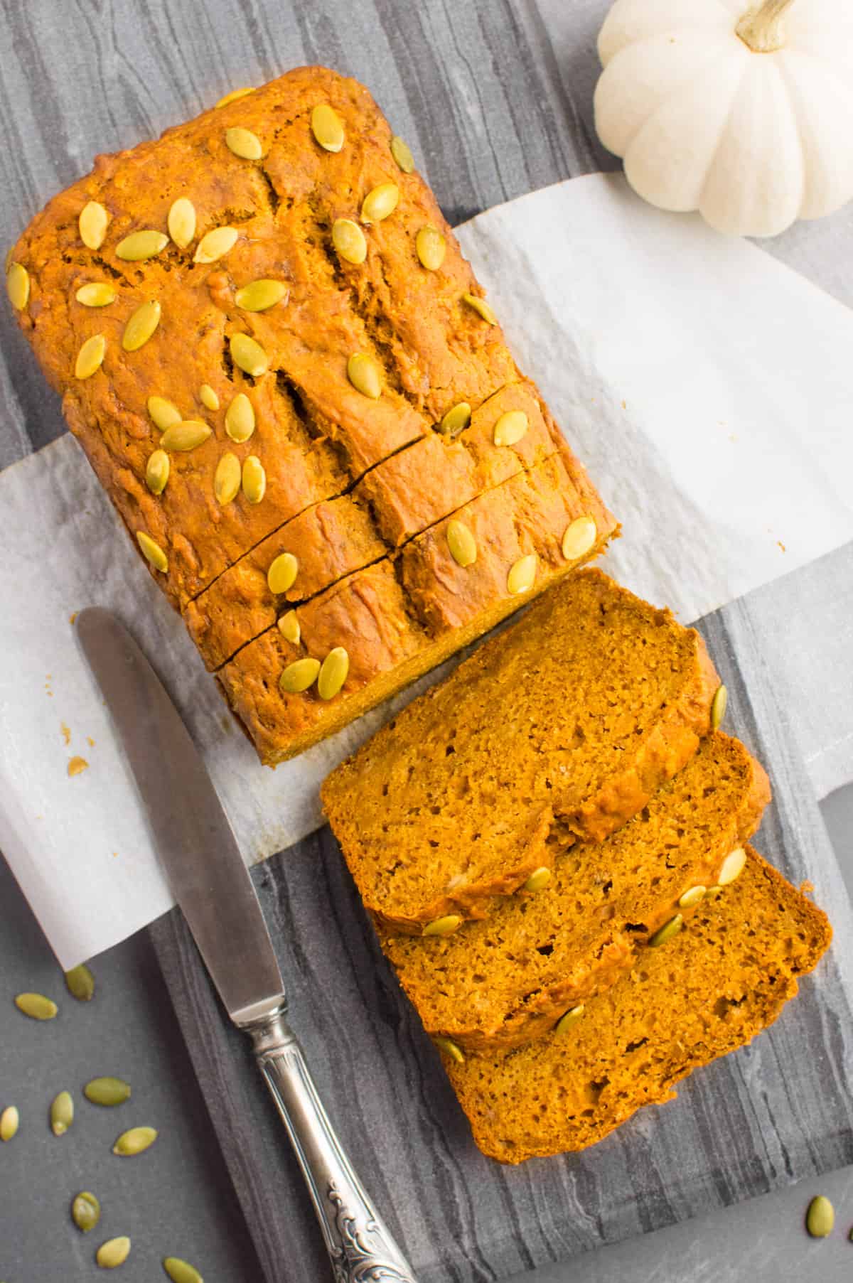 A loaf of pumpkin bread with three slices cut from it.