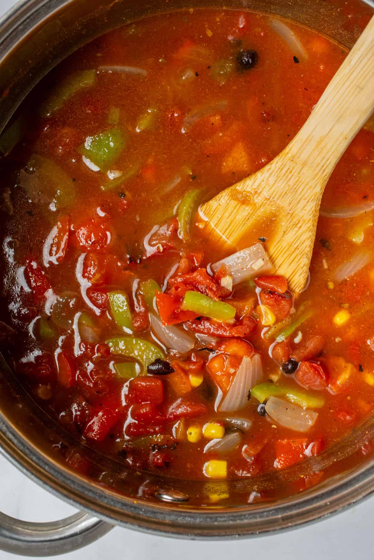 Vegan taco soup in a large pot with a wooden spoon.