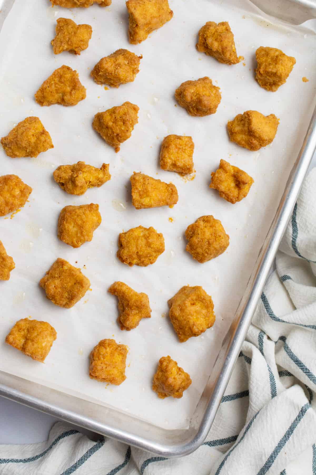 Tofu chicken nuggets on a baking sheet after baking.