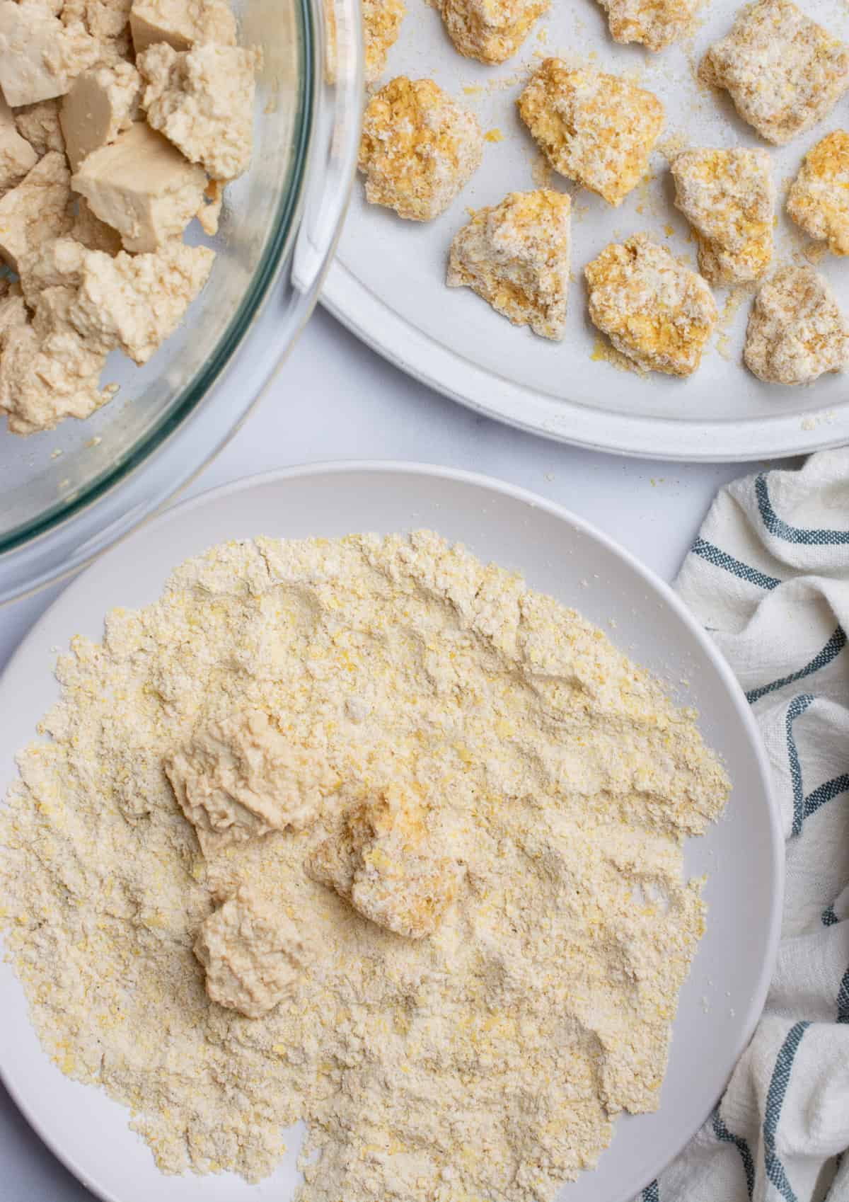 Tofu chunks being tossed in a flour breading and a plate of breaded tofu.