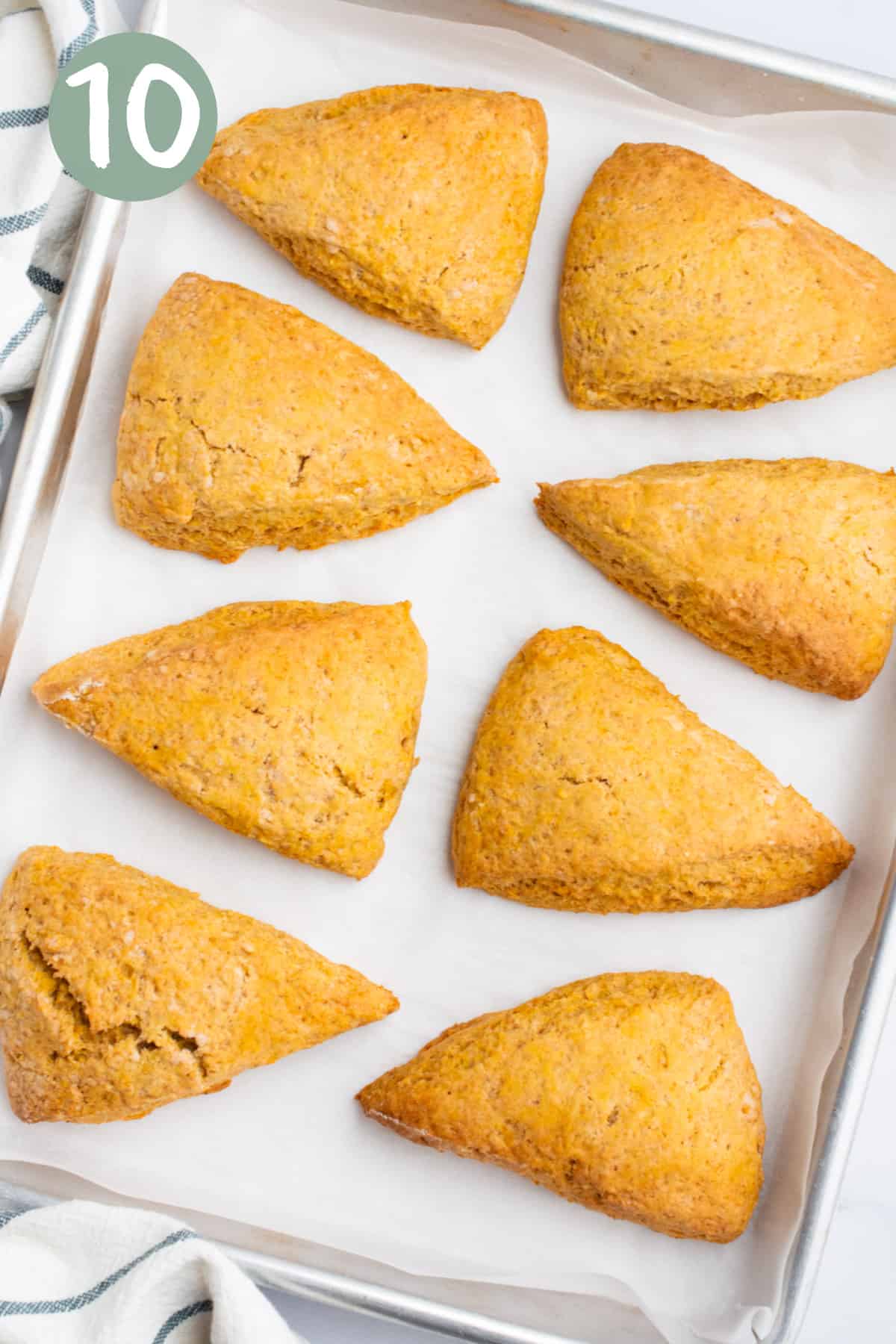 Baked vegan pumpkin scones on a baking sheet lined with parchment paper.