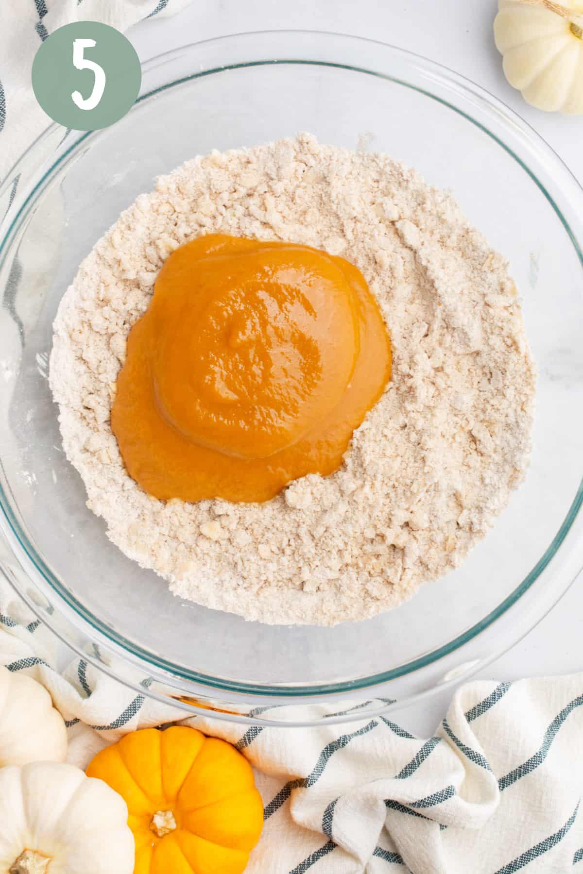 Dry ingredients and pumpkin purée in a glass bowl.