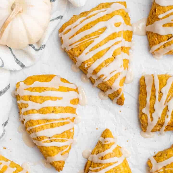 Vegan pumpkin scones drizzled with icing.