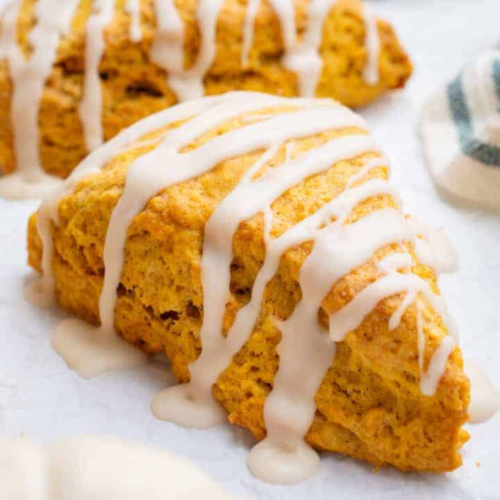 A vegan pumpkin scone drizzled with icing.