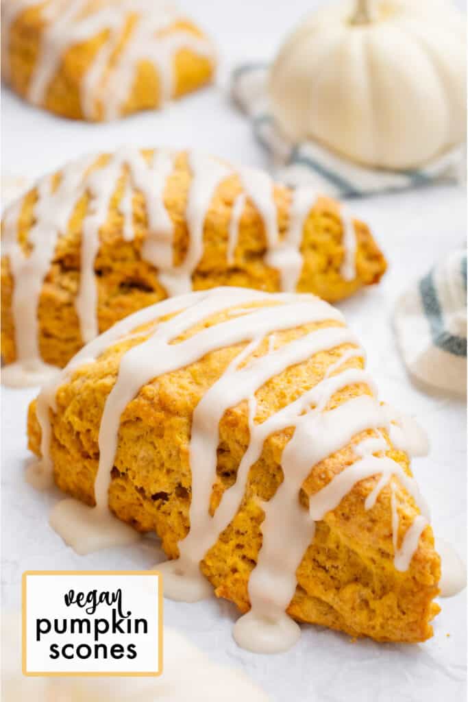 Two vegan pumpkin scones topped with glaze.