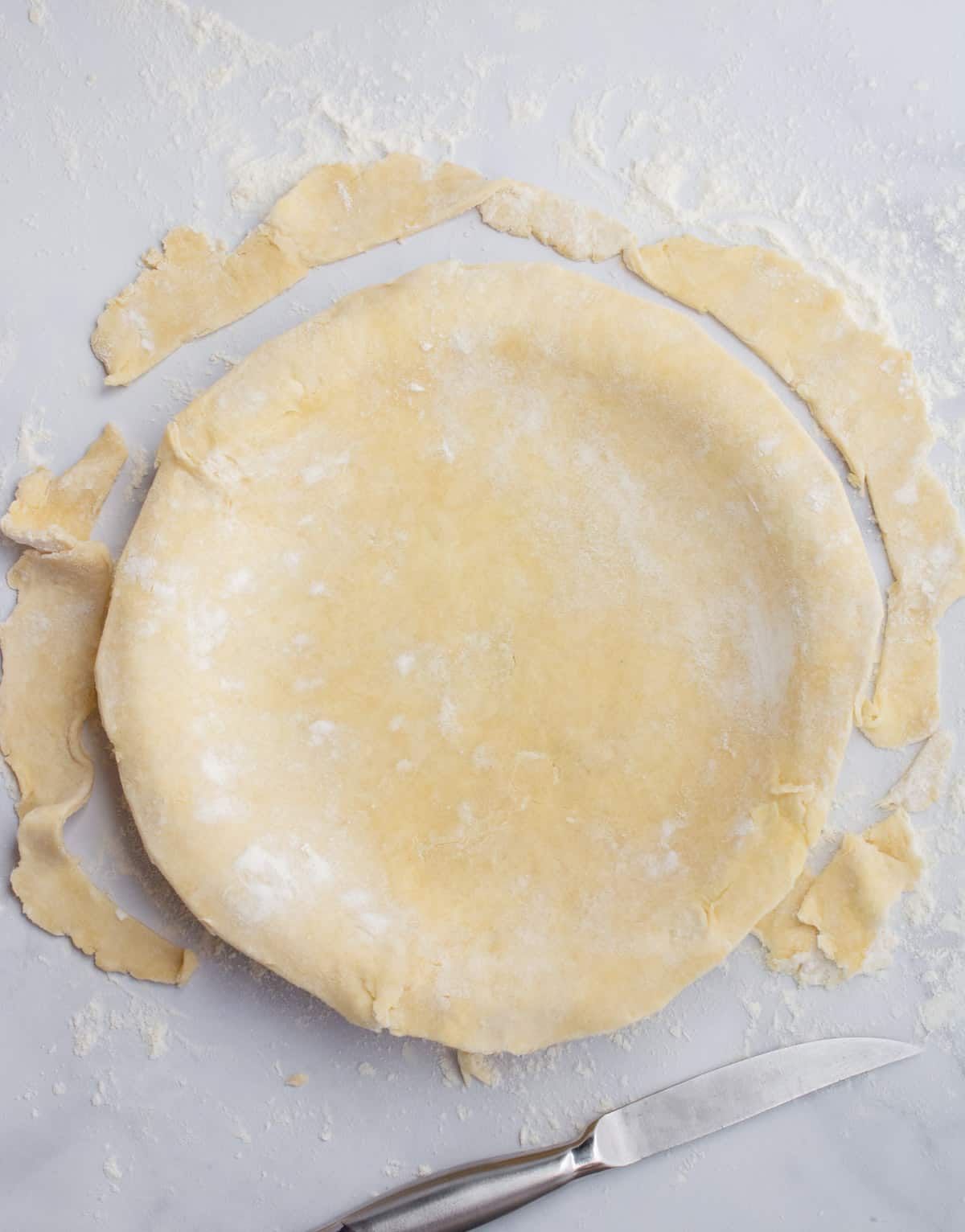 Vegan pie dough in a pie dish with the edges trimmed.