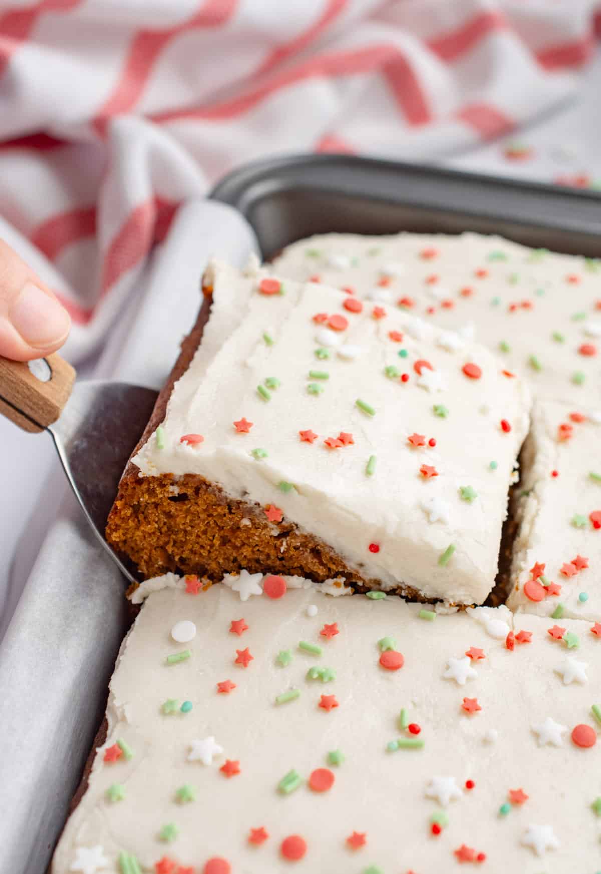 A slice of vegan gingerbread cake being removed with a cake spatula.