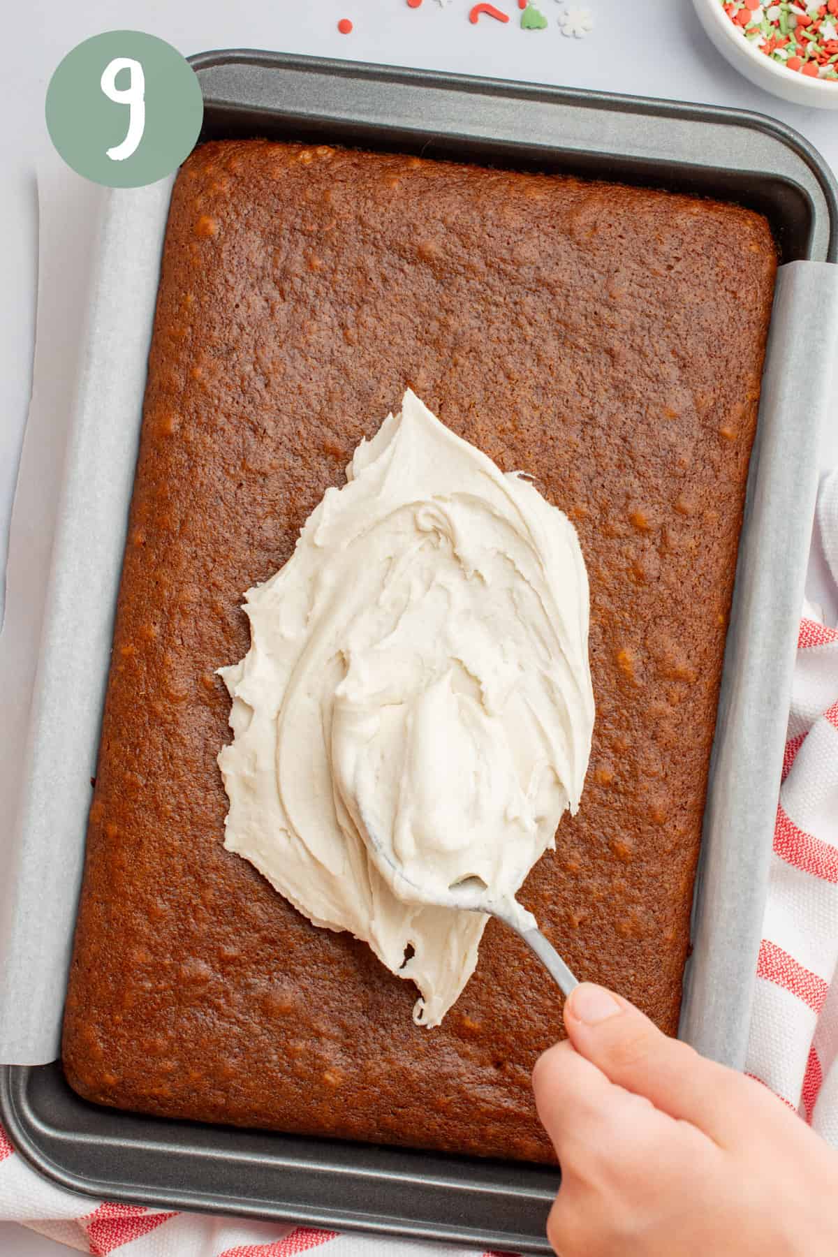 Frosting being placed on a cake with a spoon.