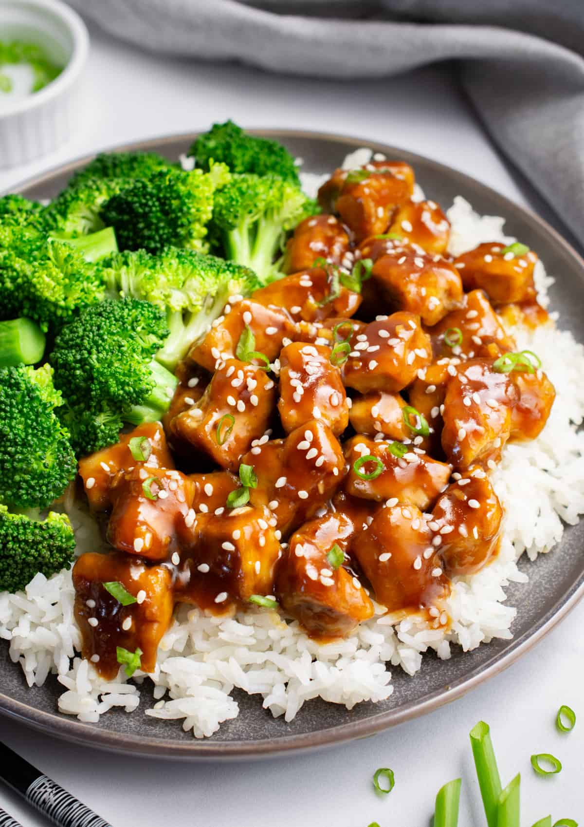 A plate of white rice, teriyaki tofu and steamed broccoli.