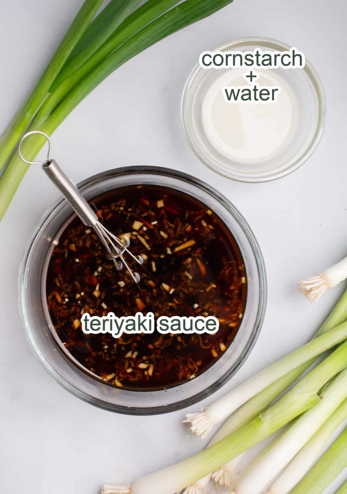A glass bowl of homemade teriyaki sauce with fresh ginger and garlic and a bowl of water and cornstarch mixed.