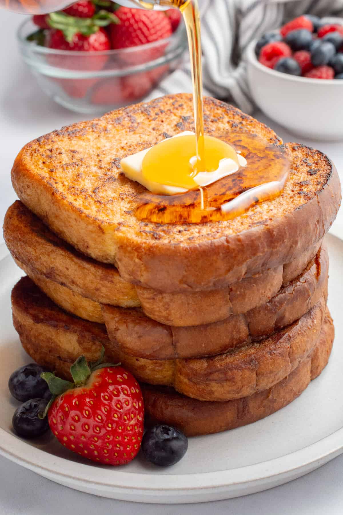 Syrup being poured on a stack of eggless french toast.