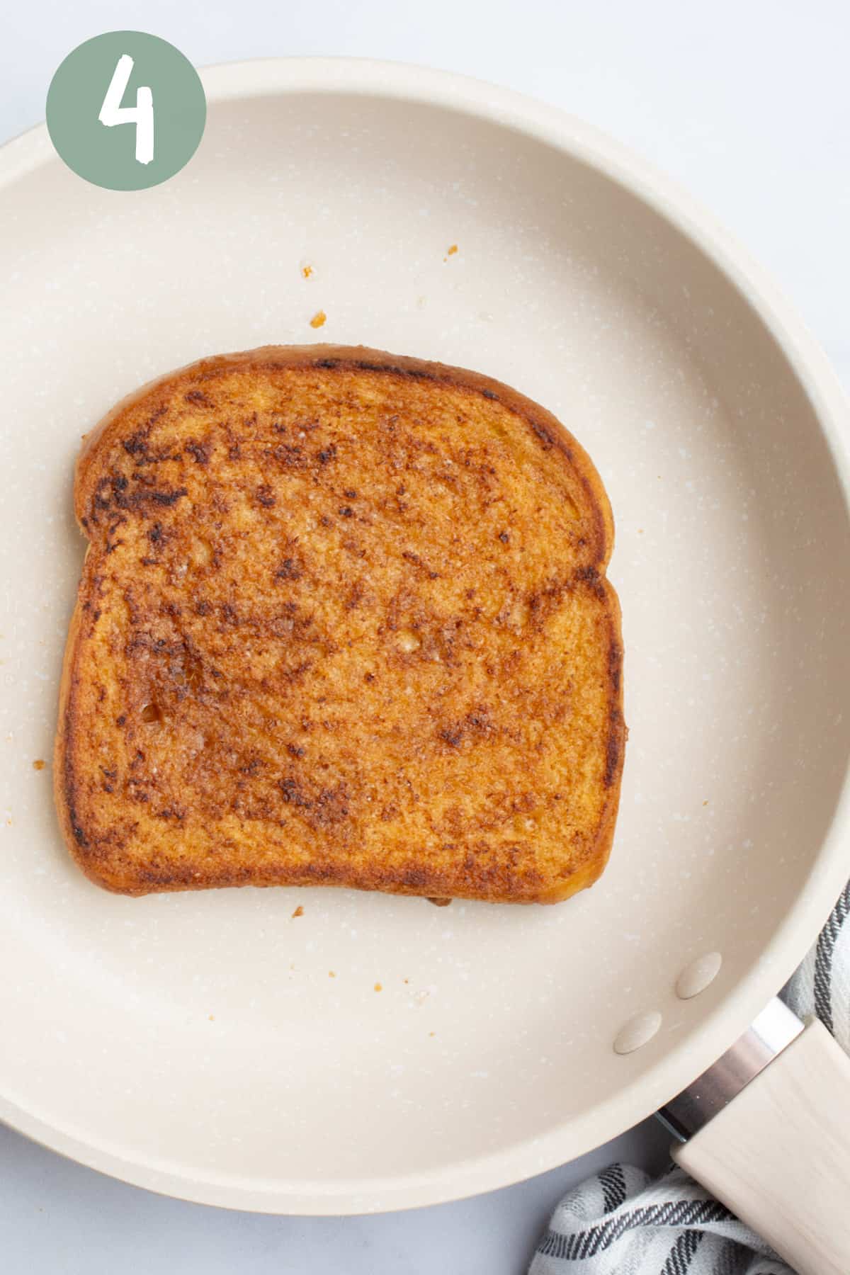 A slice of vegan french toast cooking on a pan.