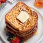 Vegan french toast topped with a butter square and syrup.