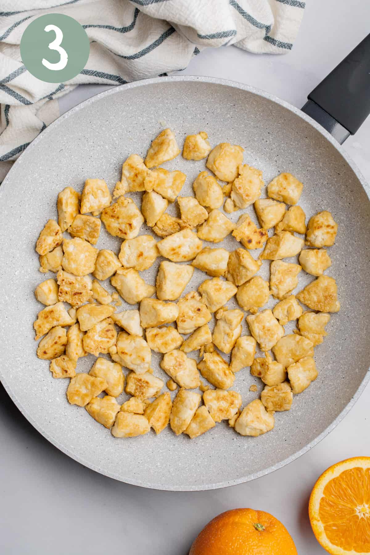 Pan-fried tofu chunks in a pan.