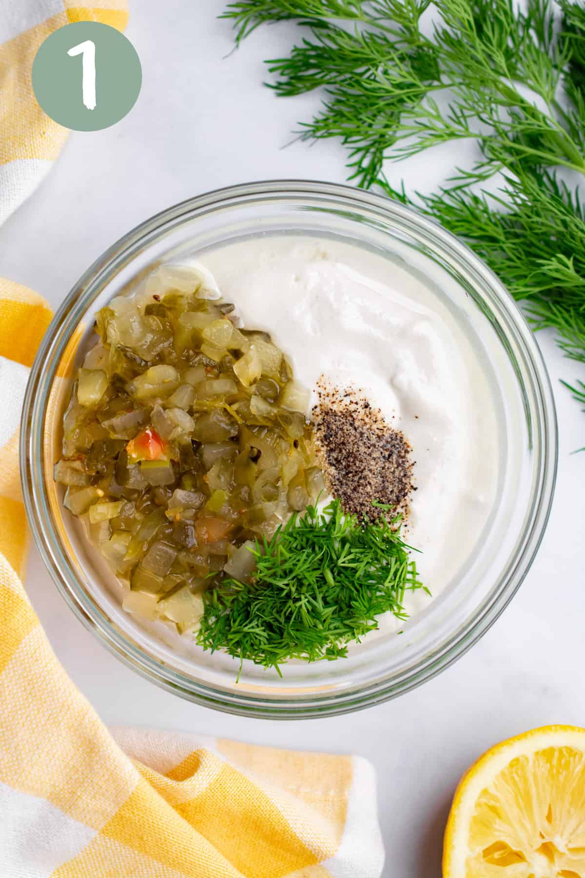 vegan mayo, dill relish, black pepper, fresh dill, and lemon juice in a glass bowl.