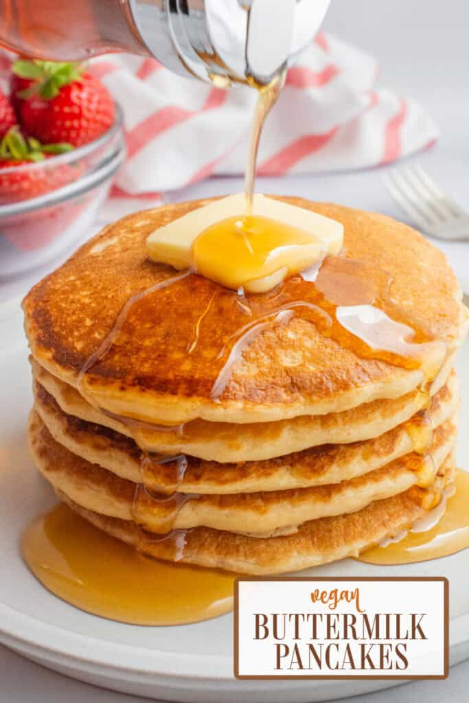 A stack of vegan buttermilk pancakes topped with butter and maple syrup.