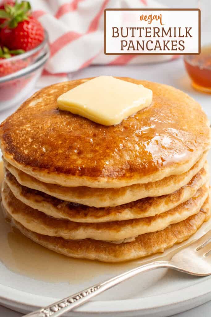 A stack of vegan buttermilk pancakes topped with butter and maple syrup.