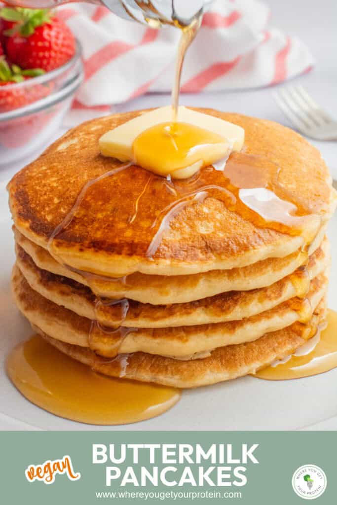 Pancakes topped with a pat of butter and drizzled in maple syrup.