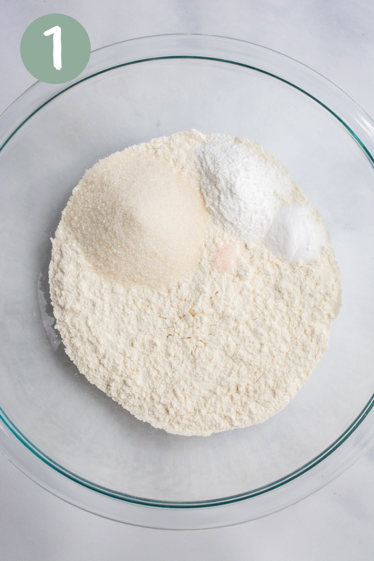 Flour, baking soda, baking powder, cane sugar, and salt in a glass bowl.