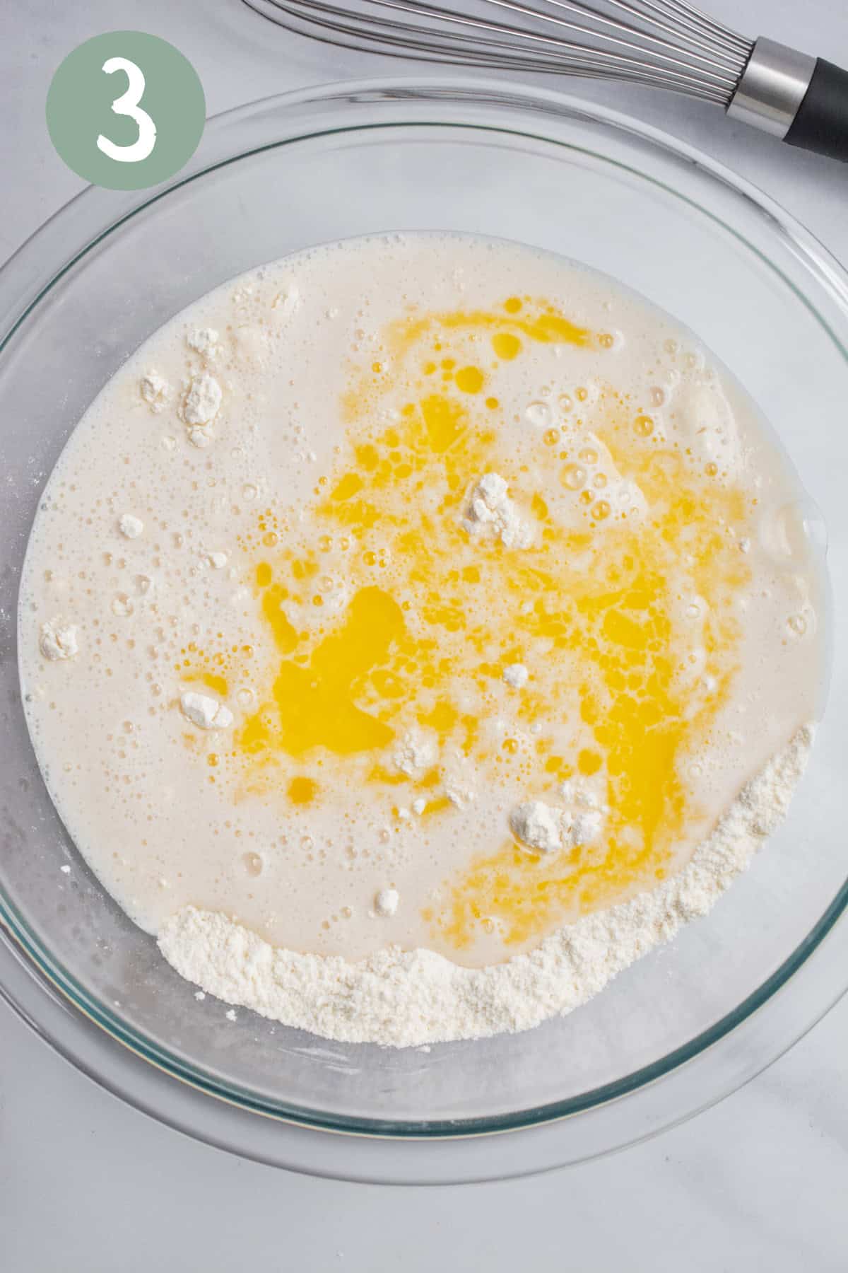 A glass bowl of flour, buttermilk, and butter.