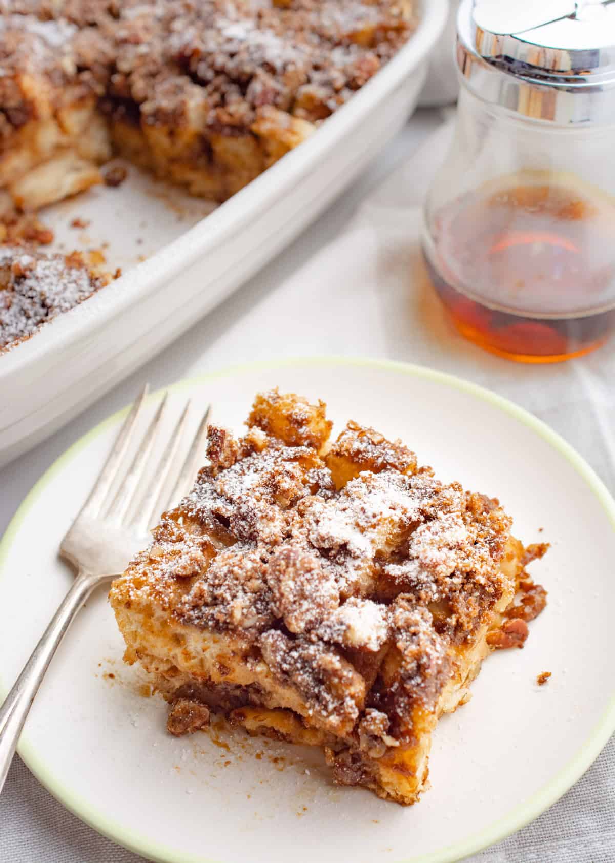 A slice of vegan baked french toast on a plate with a fork.