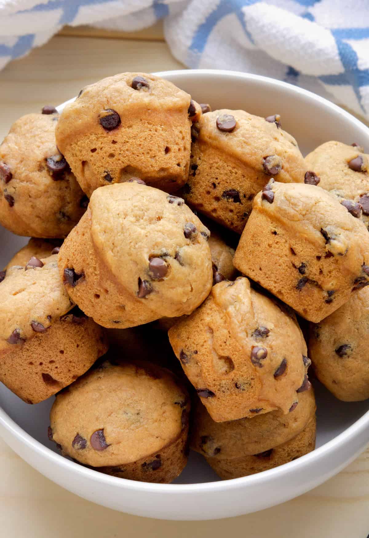 A bowl of mini vegan chocolate chip muffins on a table.