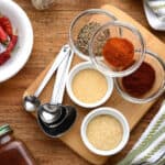 Spices in small bowls on a cutting board