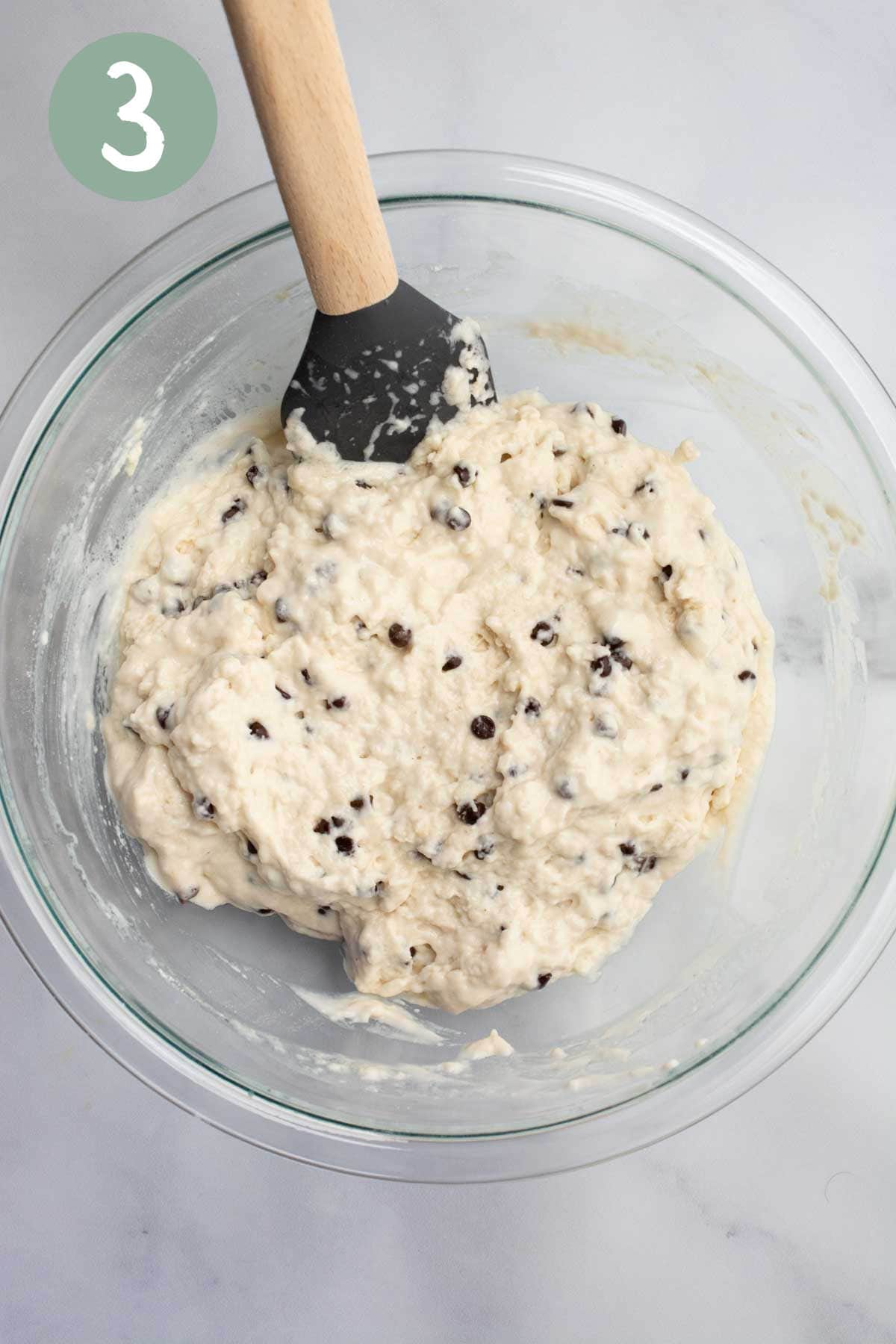 Chocolate chip muffin batter in a glass bowl.