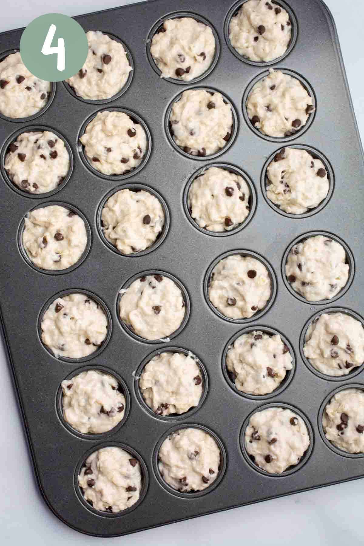 Vegan chocolate chip muffin batter in the cups of a mini muffin pan.