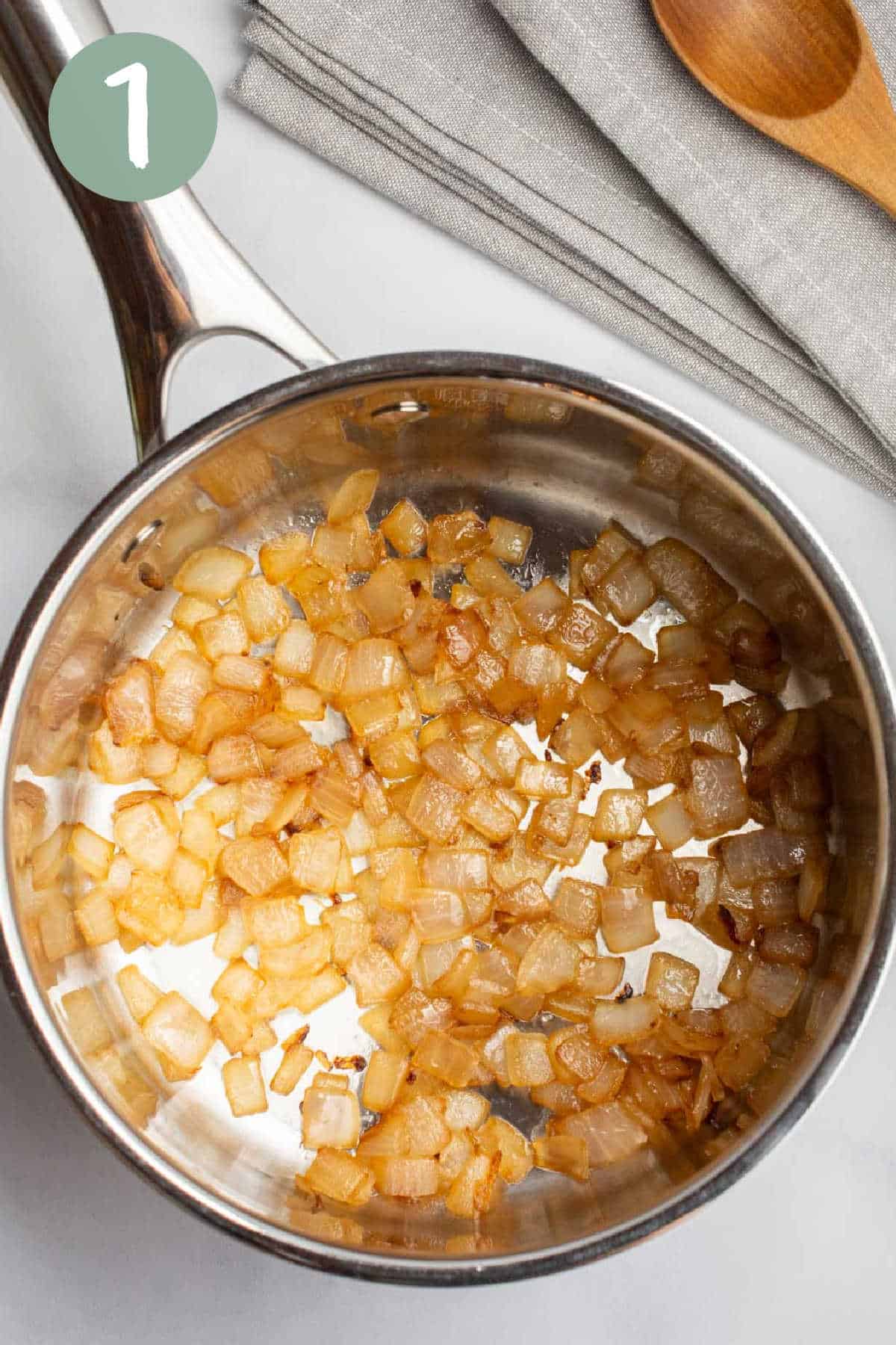 Sautéed diced onion in a saucepan.